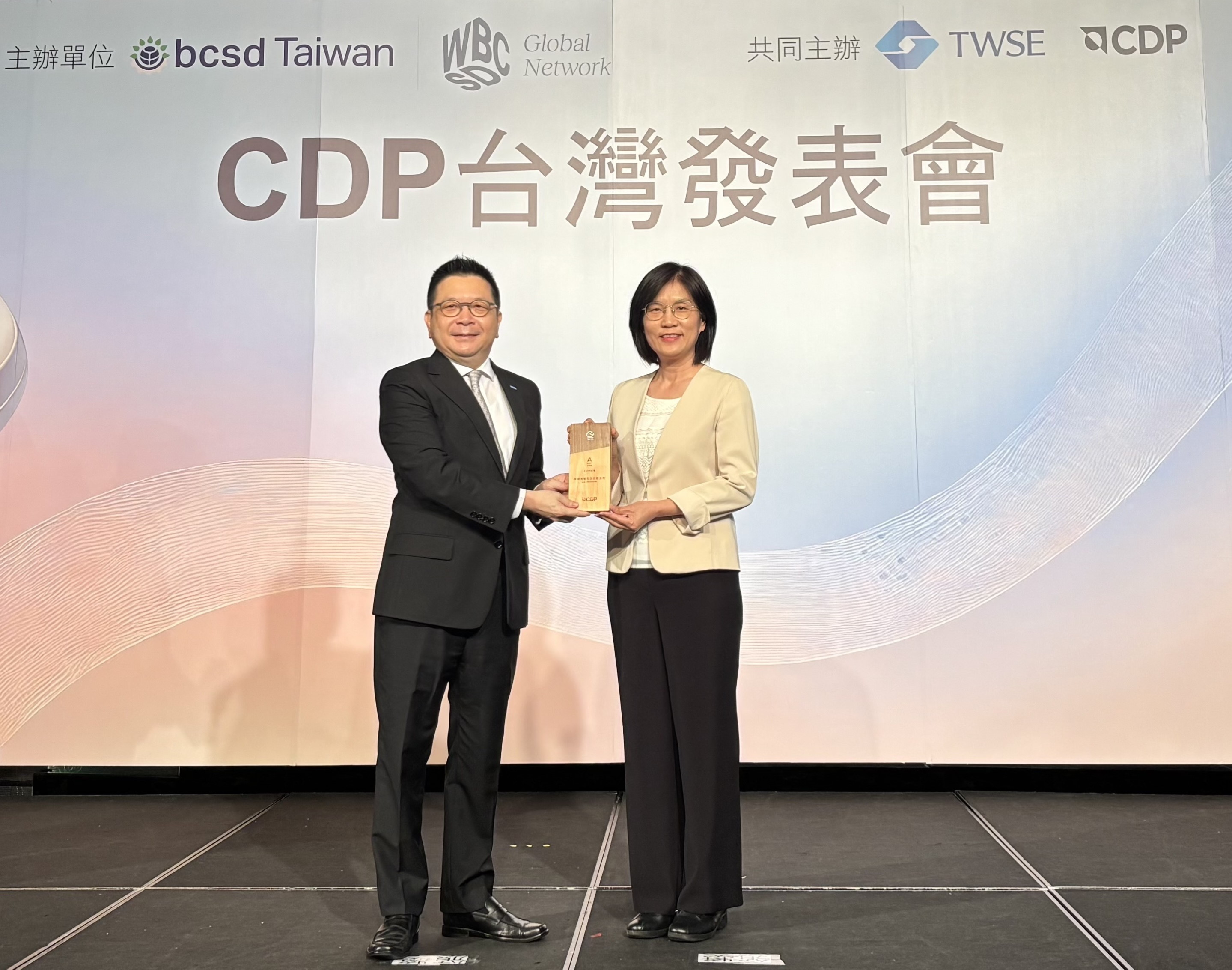 友達永續成果再獲國際評比肯定，獲頒CDP氣候與水資源雙項領導力評級。今由臺灣證券交易所董事長林修銘（左）頒獎，友達光電永續長古秀華（右）代表受獎